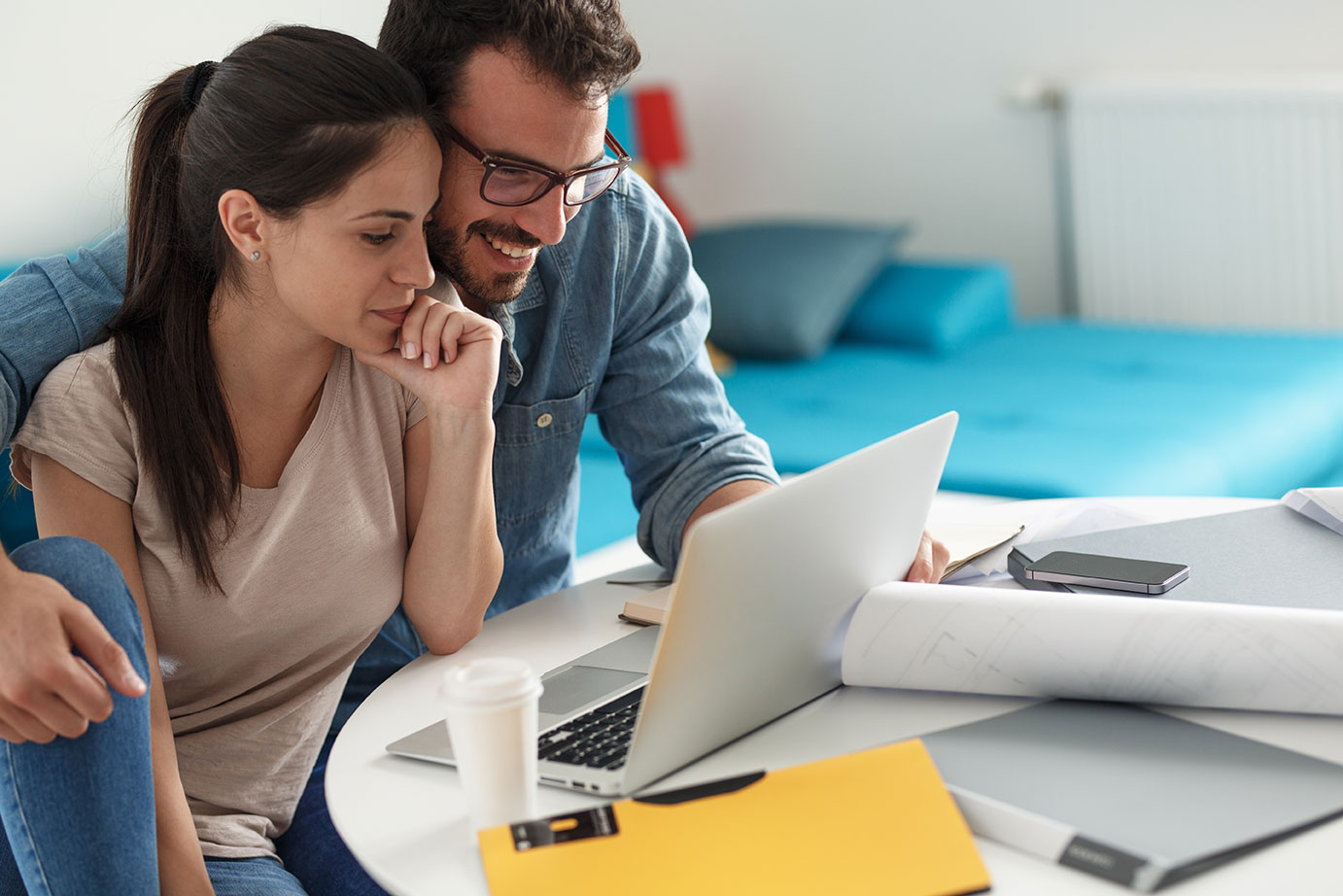 Young couple reviewing life insurance and annuity options online while planning their financial future at home.