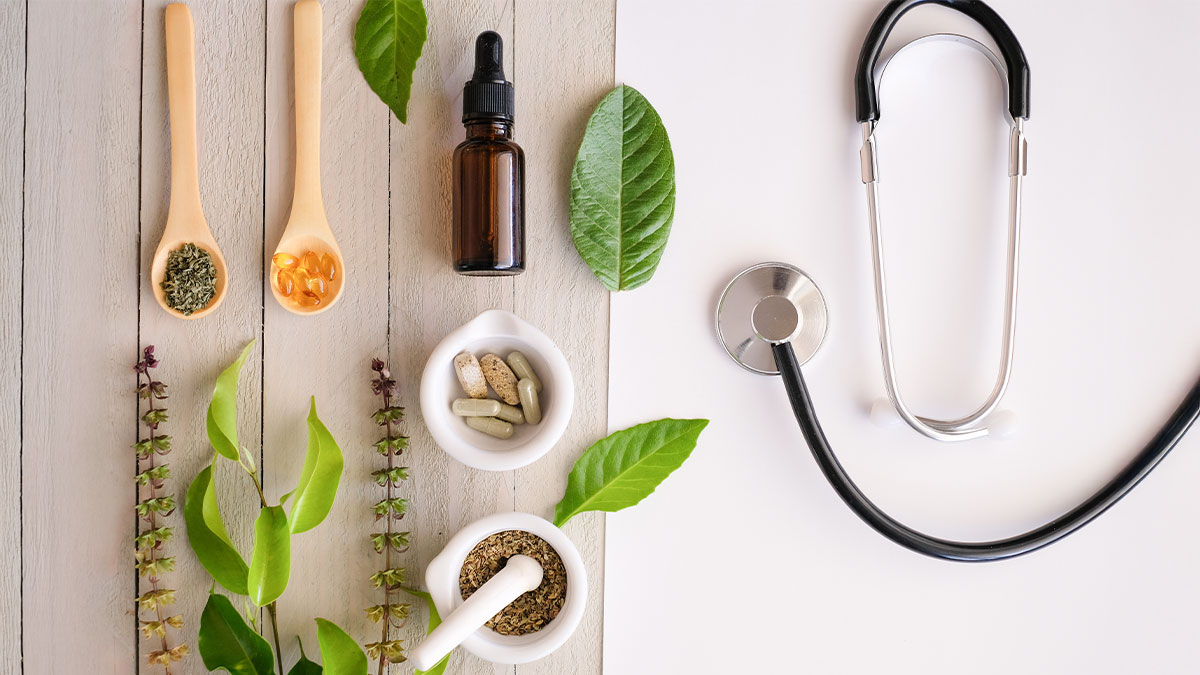 Top view of various natural remedies on a wooden countertop next to a stethoscope